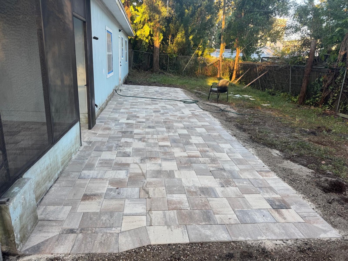 Backyard patio in light pavers at sunset